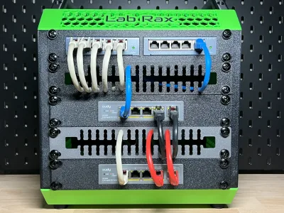 The 10-inch rack from the front: two switches, a patch panel and the black panel with pale and blue patch cables routed through it