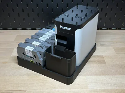 The printer sits on the right in the station, four tape cassettes inserted in front on the left